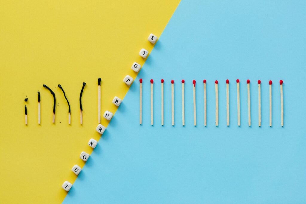 Illustration of burnout concept with burned matches and letter cubes spelling 'Stop Burnout.'