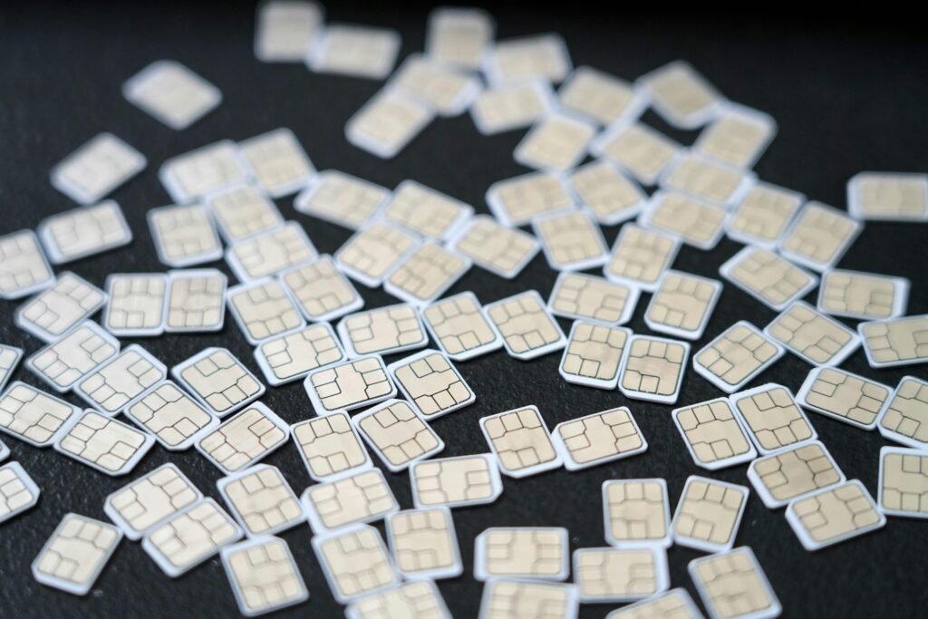 A collection of SIM cards scattered on a dark surface, showcasing modern cellular technology.