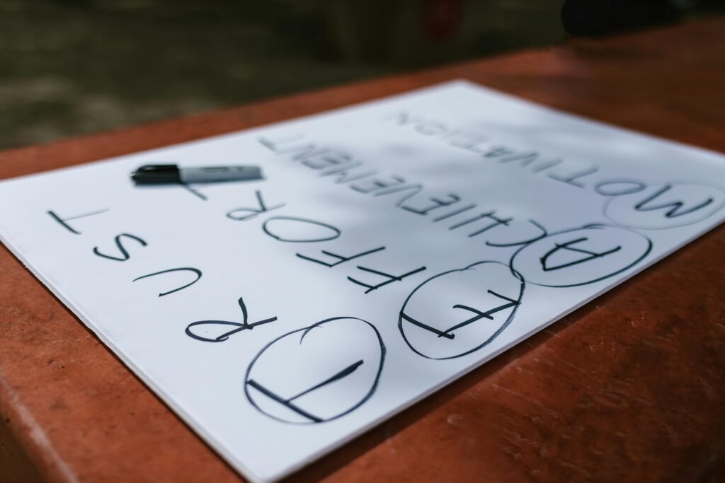 A paper with motivational words and markings placed outdoors on a table.